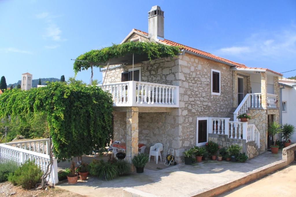 a stone house with a porch and a balcony at Apartments with a parking space Sali, Dugi otok - 8084 in Sali