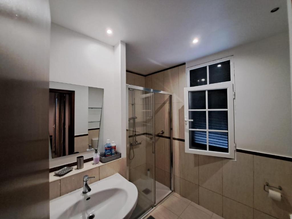 La salle de bains est pourvue d'un lavabo et d'une douche. dans l'établissement Friendly house, à Funchal