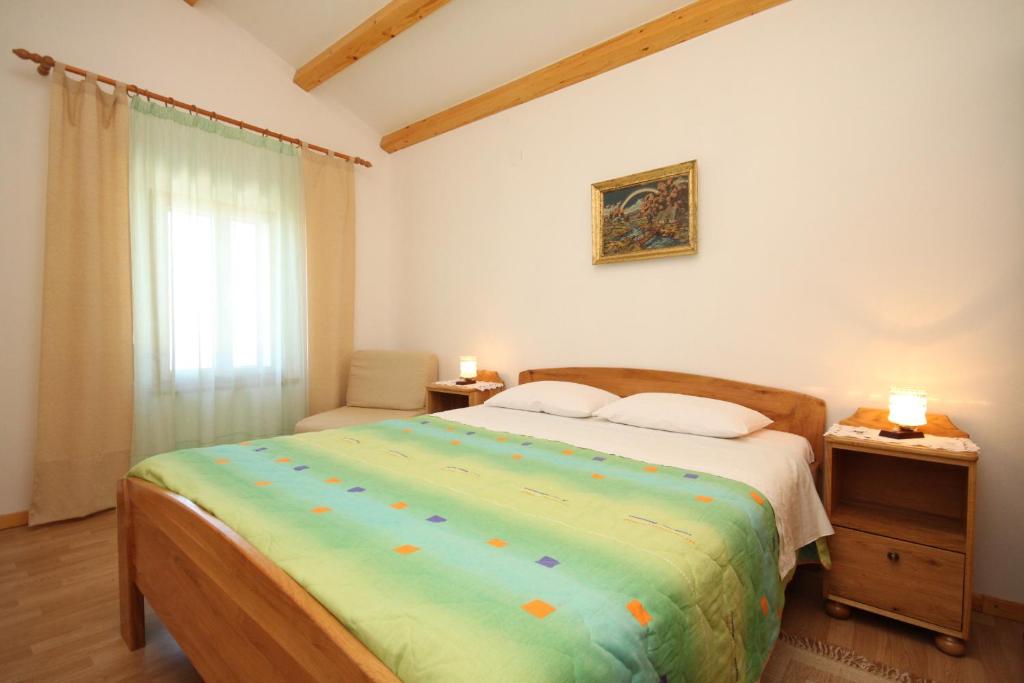 ein Schlafzimmer mit einem Bett und einem Stuhl und einem Fenster in der Unterkunft Seaside holiday house Miholascica, Cres - 8073 in Martinšćica