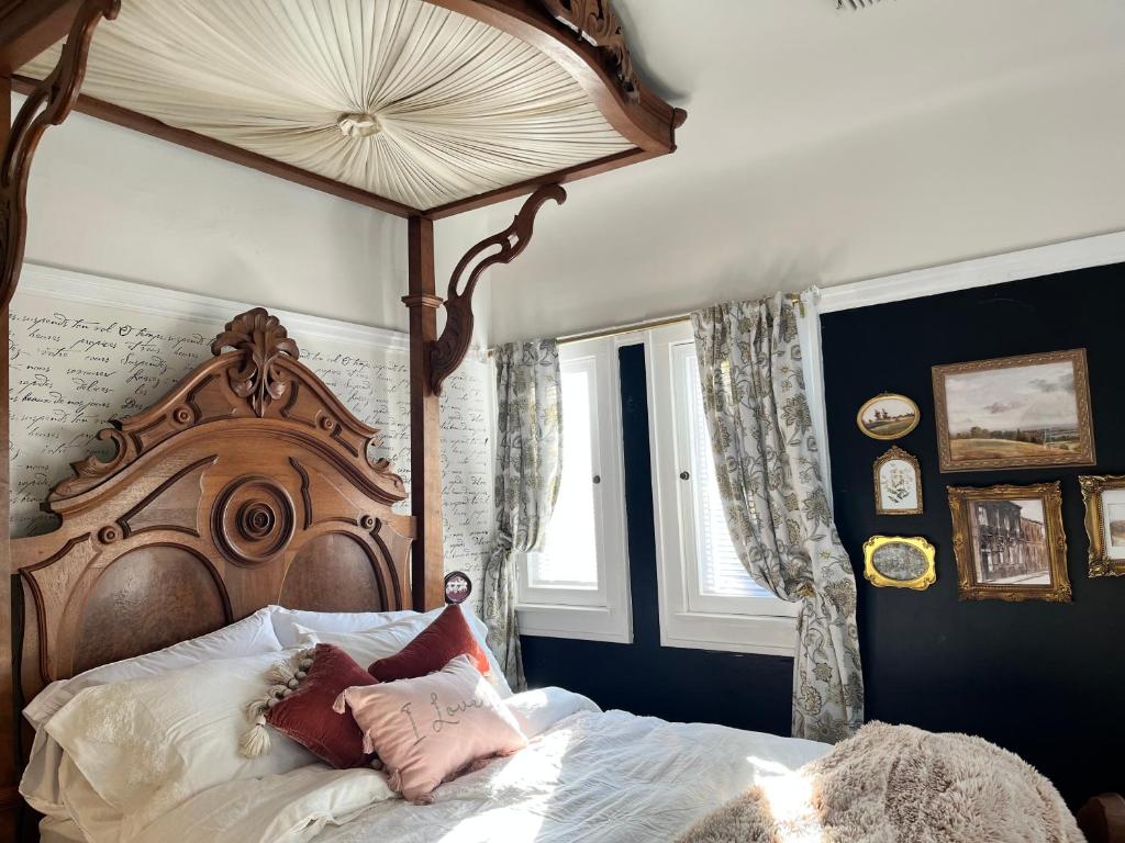 1 dormitorio con cama de madera con dosel y almohadas en Harbinson House, en Sacramento