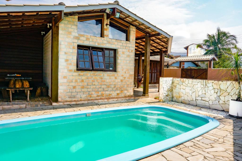 a swimming pool in front of a house at Hostel Carcará in Caraguatatuba