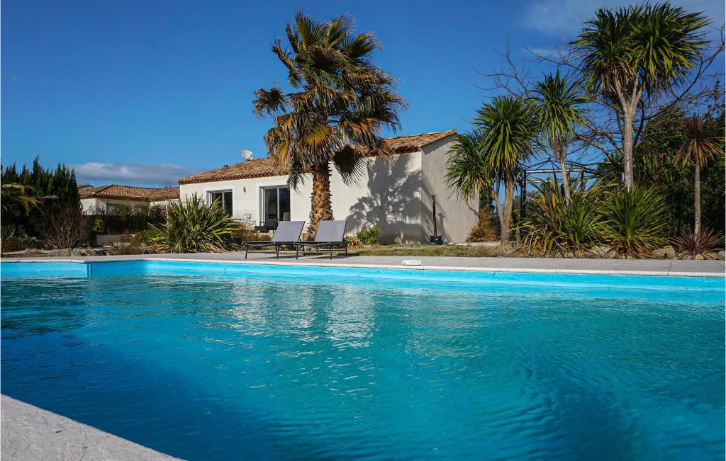 - une piscine en face d'une maison avec des palmiers dans l'établissement Amazing Home In Saint-gnies-de-fonted With Private Swimming Pool, Can Be Inside Or Outside, à Saint-Geniès-de-Fontedit