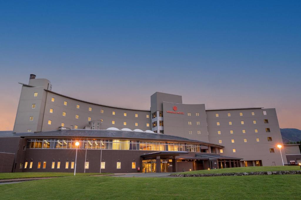 KAMENOI HOTEL Aso في آسو: مبنى مستشفى كبير مع مبنى مضاء