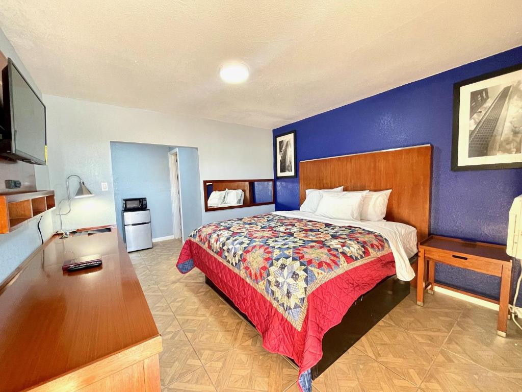 a bedroom with a bed and a blue wall at Golden Inn in Seagoville