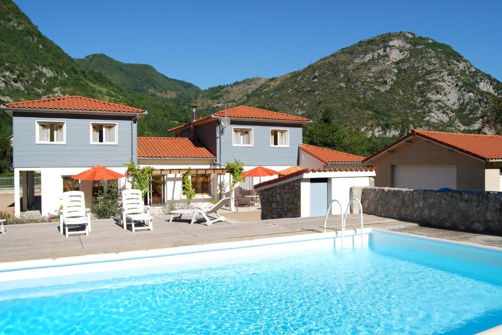 eine Villa mit einem Pool und einem Haus in der Unterkunft Les Terrasses De Castelmerle in Niaux
