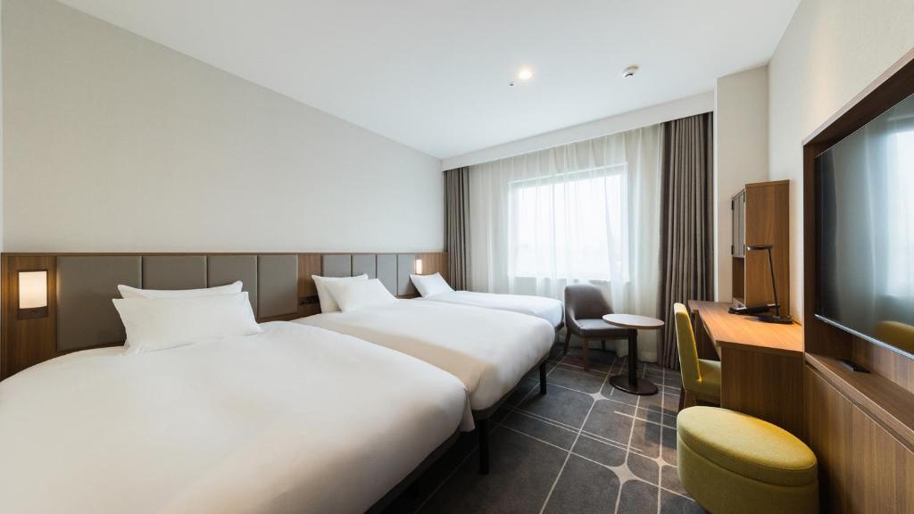 Postel nebo postele na pokoji v ubytování JR-East Hotel Mets Mejiro