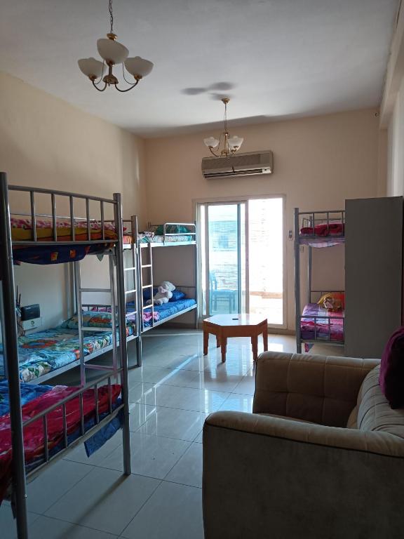 a living room with bunk beds and a couch at Suzy Hostel for boys in Dubai
