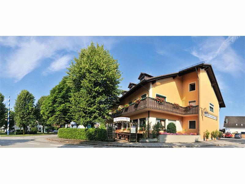 ein großes Haus mit einem Balkon an der Seite in der Unterkunft Hotel Grasbrunner Hof in Grasbrunn