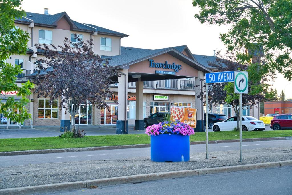 un letrero de la calle y un cubo de basura azul al lado de una calle en Travelodge by Wyndham Wetaskiwin, en Wetaskiwin