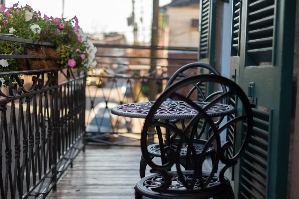 a black bench sitting on a porch with flowers at Royal Frenchmen Hotel and Bar in New Orleans