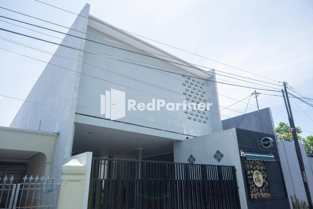 a white building with a red partner sign on it at Athena House Syariah Near The Park Mall Solo Baru Mitra RedDoorz in Sukoharjo