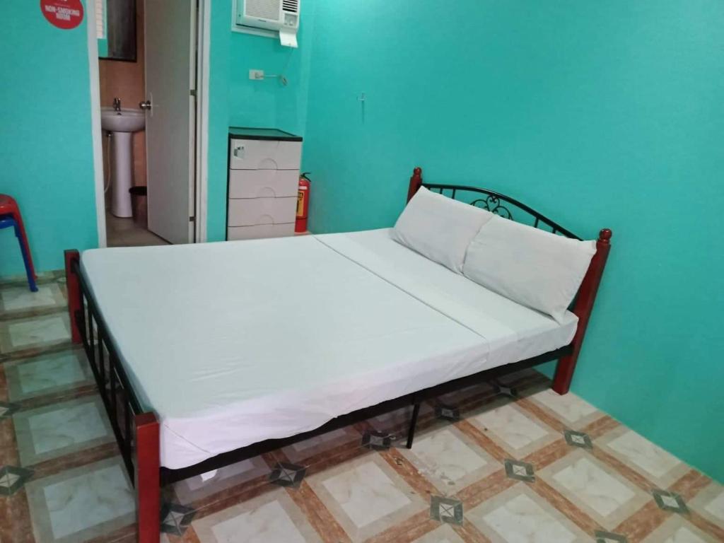 uma cama num quarto com uma parede azul em Cebu Leisure Lodge em Cebu