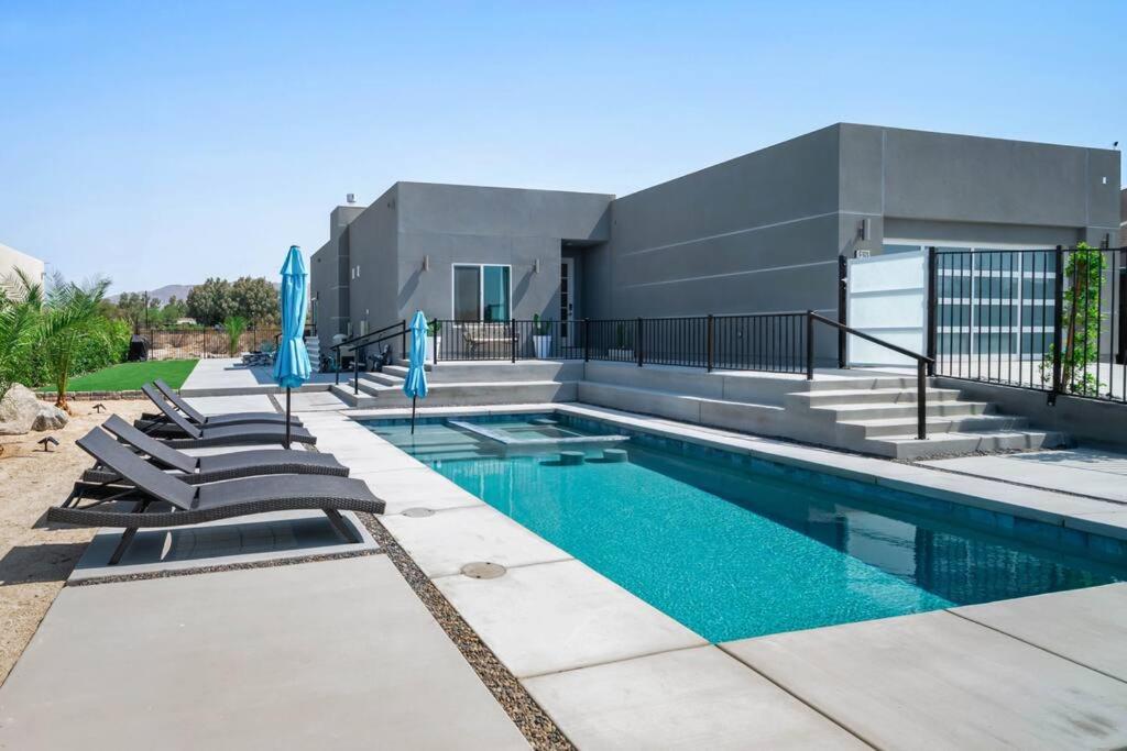 uma piscina com espreguiçadeiras ao lado de uma casa em Modern Desert Oasis – Pool, Spa and Mountain Views em Desert Hot Springs