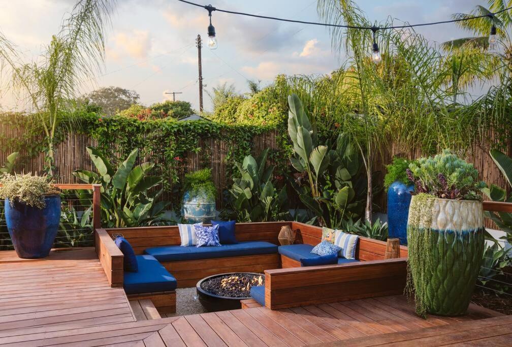 a patio with couches and blue chairs and plants at Tropical Beach Villa with Deck, Spa Walk to Ocean in Santa Barbara