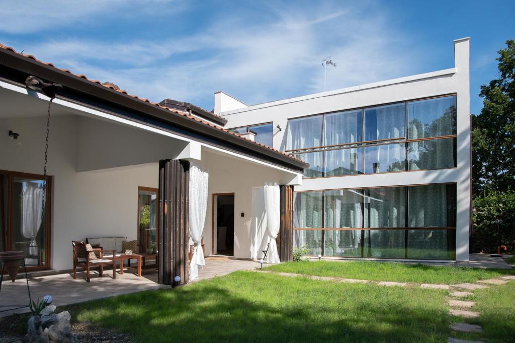 a white house with a patio and a yard at La Casa di Gabri in Málchina