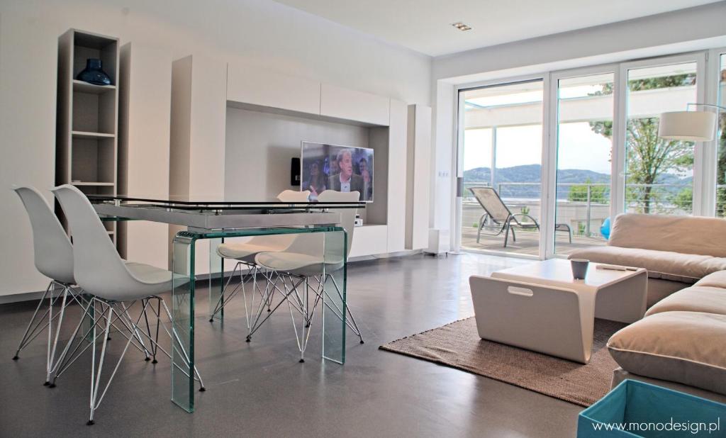 a living room with a glass table and chairs at Słoneczny Gródek 72 in Gródek Nad Dunajcem