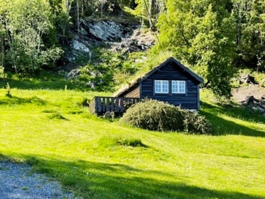 una pequeña cabaña en medio de un campo verde en Holiday home Bryggja II, en Bryggja