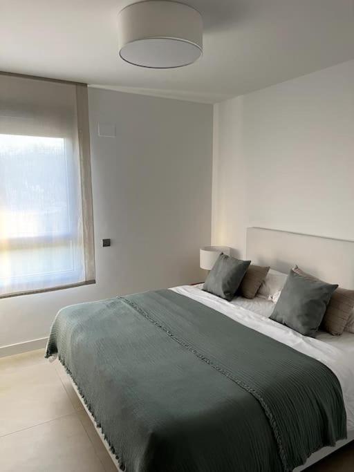 sypialnia z dużym łóżkiem i dużym oknem w obiekcie Luxury penthouse with sea view in La Cala Golf Resort w mieście La Cala de Mijas