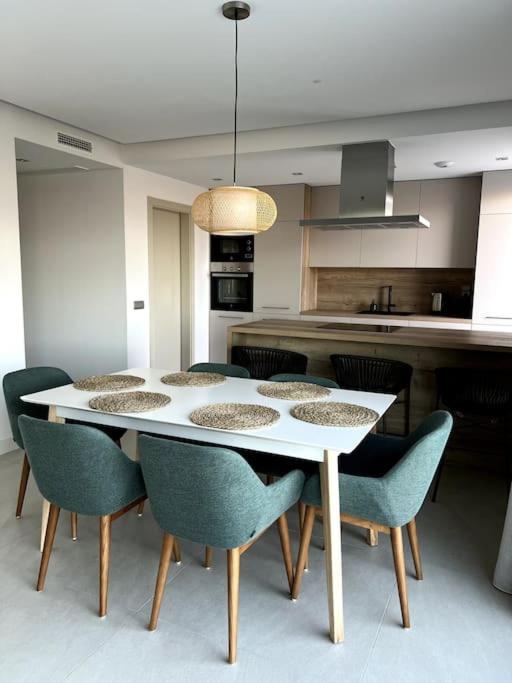 stół jadalny z krzesłami i kuchnia w obiekcie Luxury penthouse with sea view in La Cala Golf Resort w mieście La Cala de Mijas