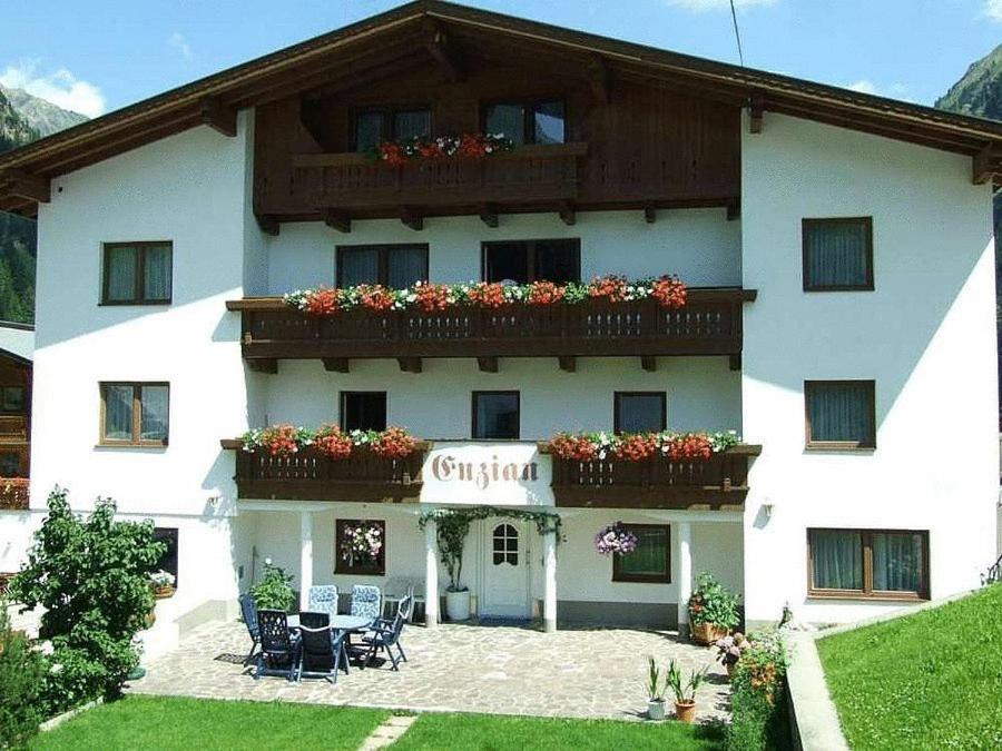 a large white building with flowers on the balconies at Haus Enzian in Sankt Leonhard im Pitztal