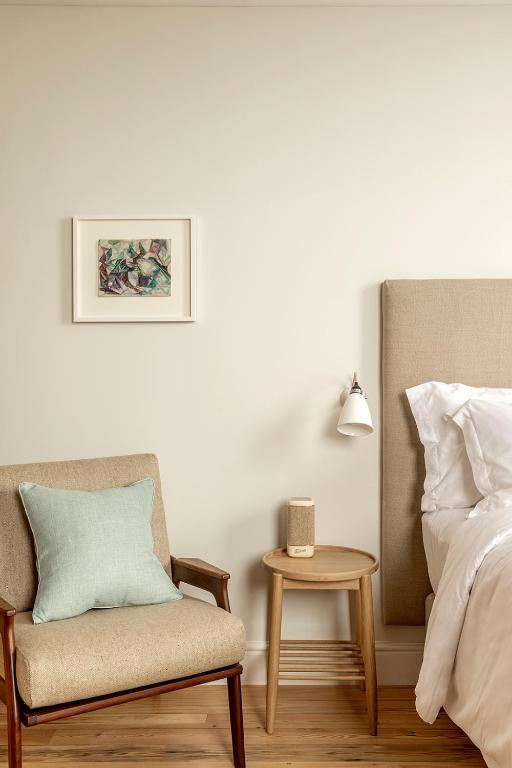 a bedroom with a bed and a chair and a table at Fort Road Hotel in Margate