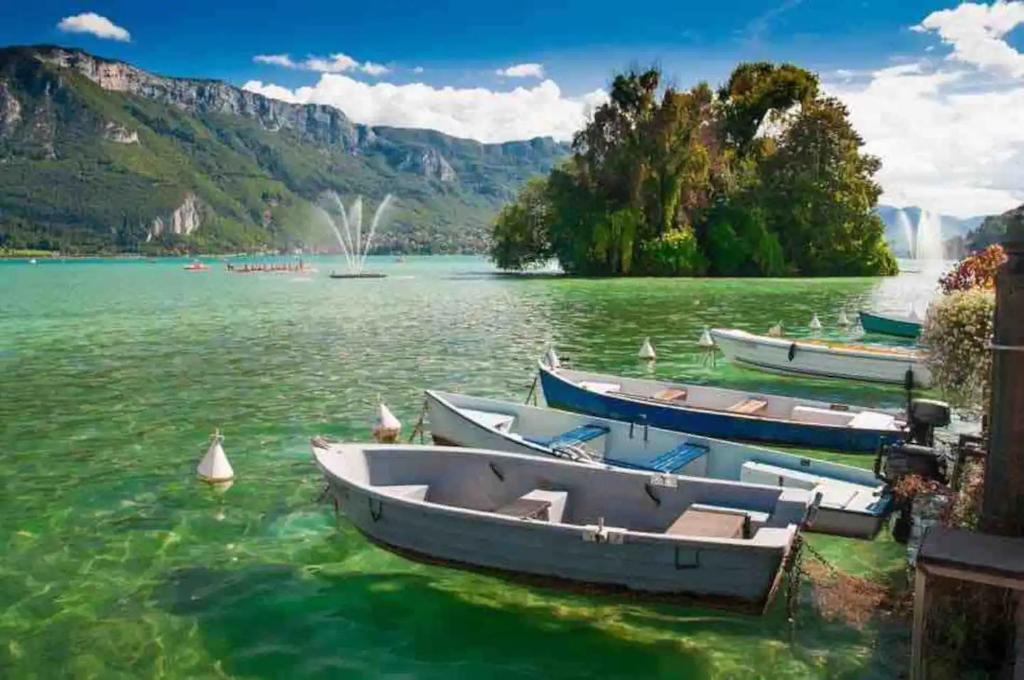 three boats on a lake with mountains in the background at Le Bouvard - MyCosyApart, Central Gare 100m, Netflix in Annecy