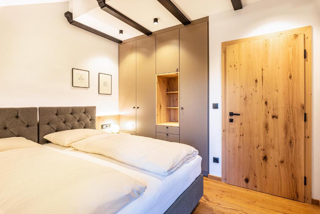 een slaapkamer met een groot bed en een houten deur bij Residence Skutial App Santner in Castelrotto