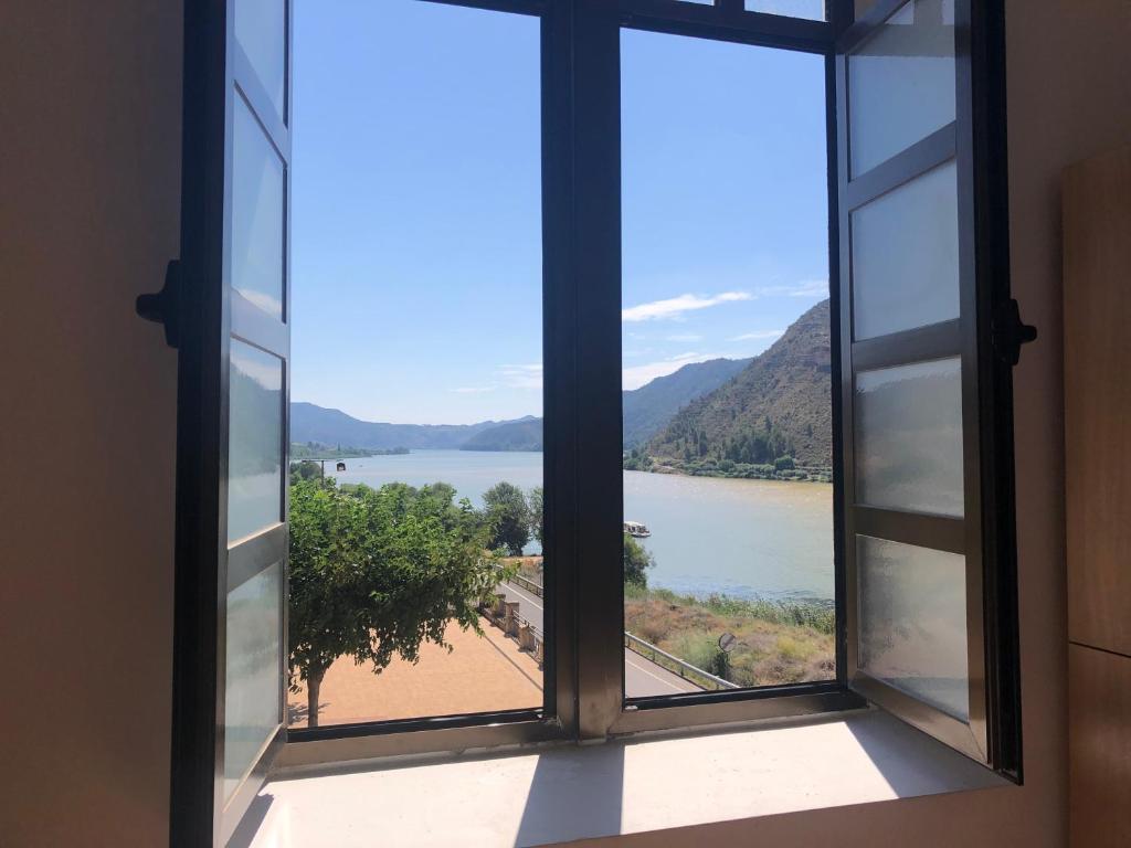 an open window with a view of a lake at Tres estrellas Camí de Sirga Mequinenza in Mequinenza