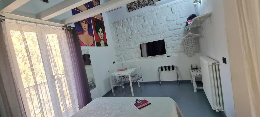 biały pokój ze stołem i oknem w obiekcie Il Museo di Teresa piazza del Teatro centrale w mieście Agrigento