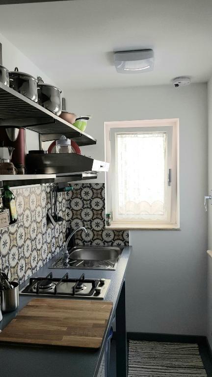 kuchnia z kuchenką i oknem w obiekcie Il Museo di Teresa piazza del Teatro centrale w mieście Agrigento