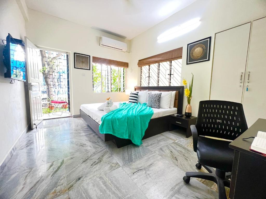 a bedroom with a bed with a green blanket on it at Olive Service Apartments Salt Lake City in Kolkata