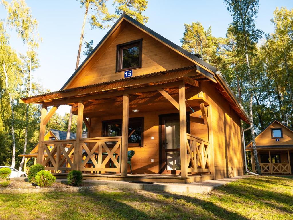 una gran cabaña de madera con techo de gambrel en Ośrodek Wypoczynkowy Laguna, en Lubniewice