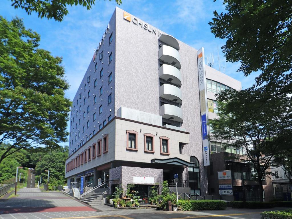 橫濱的住宿－Chisun Inn Yokohama Tsuzuki，一座高大的建筑,旁边有一个标志