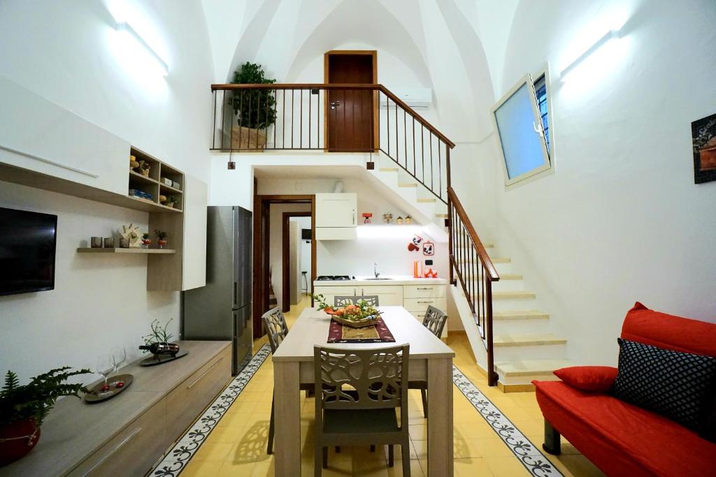 a living room with a table and a staircase at Aretè Apartments in Lecce