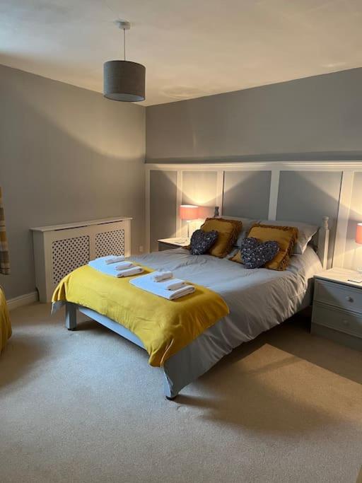 a bedroom with a large bed with yellow sheets and pillows at The Old Pie Shop Hebden Bridge in Hebden Bridge