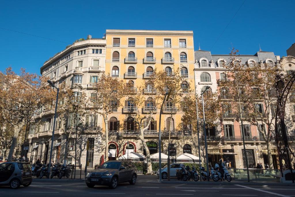 a large building with cars parked in front of it at Hostalin Barcelona Passeig de Gràcia in Barcelona