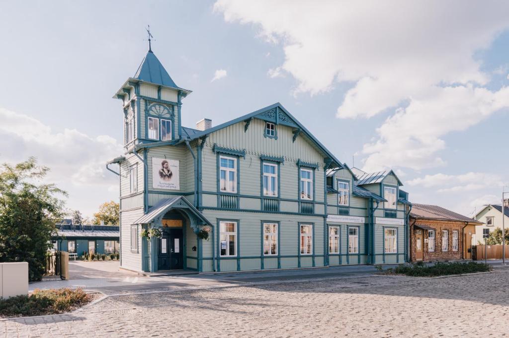 um grande edifício azul e branco com uma torre de relógio em Villa Fannyhof em Haapsalu