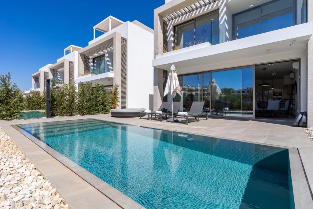 a villa with a swimming pool and a house at Cyan 3-Bedroom Villa in Protaras in Paralimni