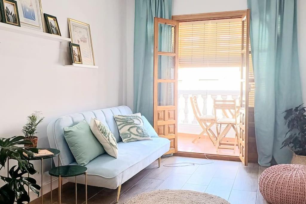 a living room with a couch and an open door at Meraki: tu hogar en Frigiliana in Frigiliana