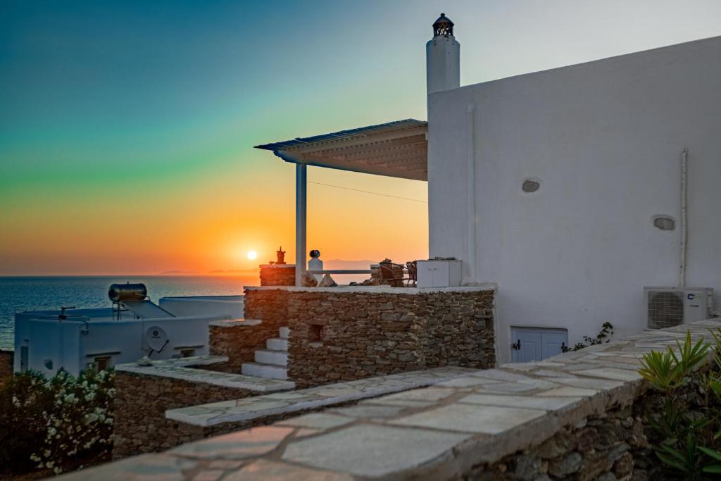 um pôr-do-sol sobre o oceano de uma casa em Irilena's guest house em Faros