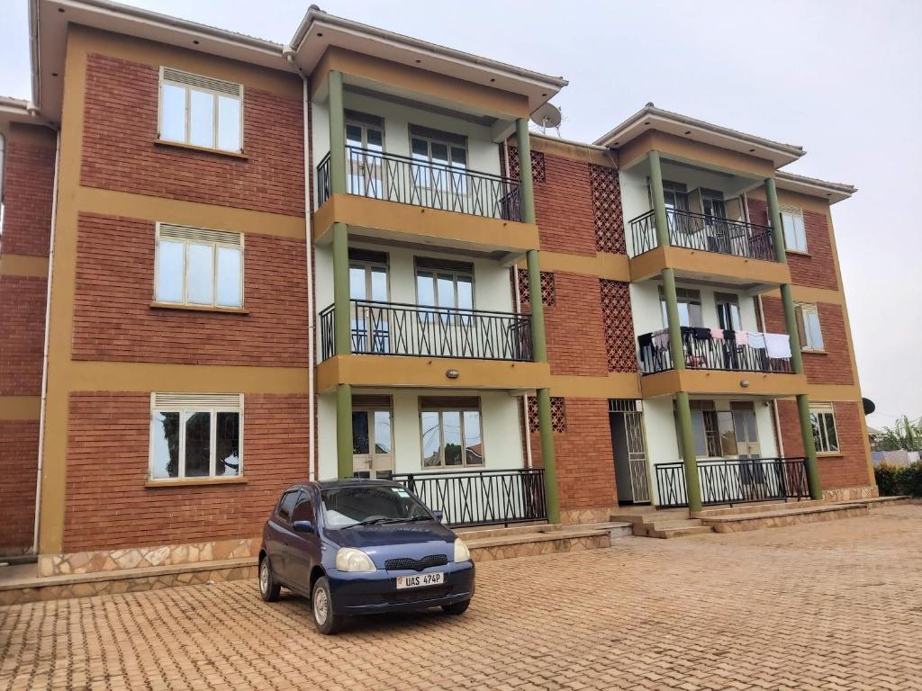 ein vor einem Backsteingebäude geparkt in der Unterkunft OCTA HOMES in Kampala