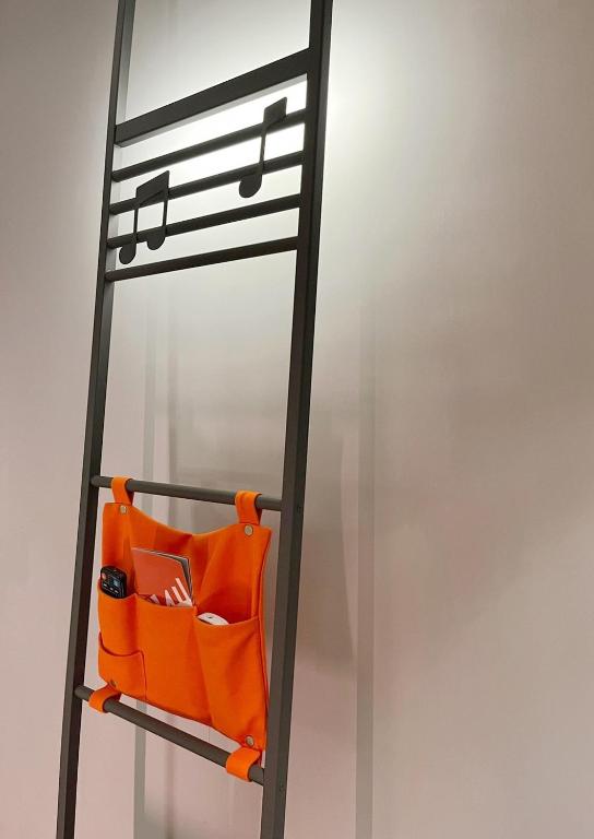 an orange chair under a ladder with music notes at OLAH Poshtel - Taichung Station in Taichung