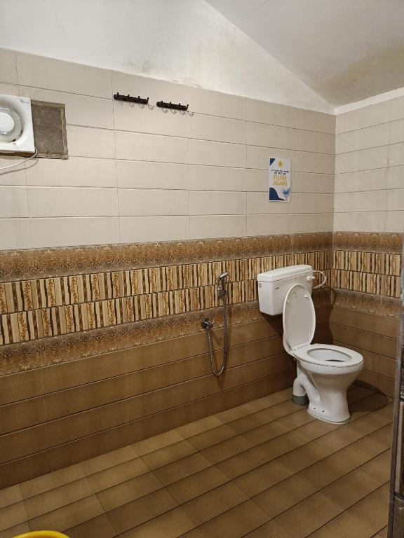 a bathroom with a toilet and a shower at BunkNBrew in Palolem