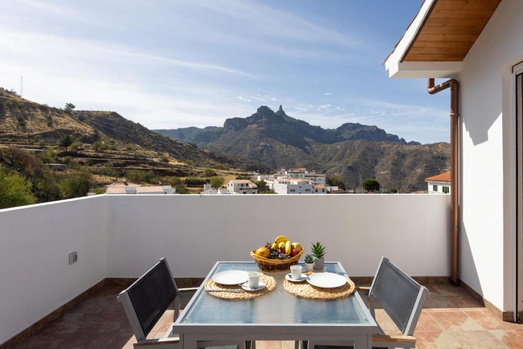 a table on a balcony with a view of mountains at Casa Maria with Roque Nublo view in Tejeda
