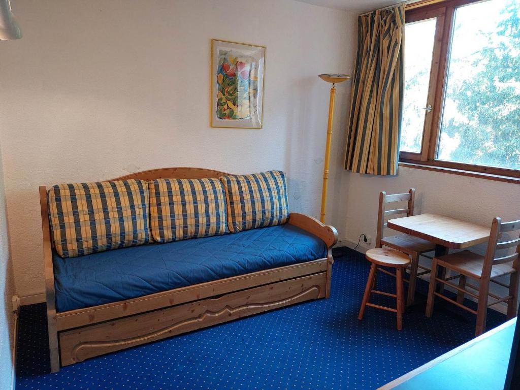 Ce lit se trouve dans un dortoir doté d'une table et d'une table. dans l'établissement Studio cosy pour 2 personnes, proche pistes et commodités, Arc 1800 - FR-1-411-293, à Arc 1800