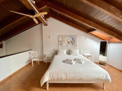 a bedroom with a white bed and a ceiling fan at GOLF SOJUELA naturaleza Pet friendly in Sojuela