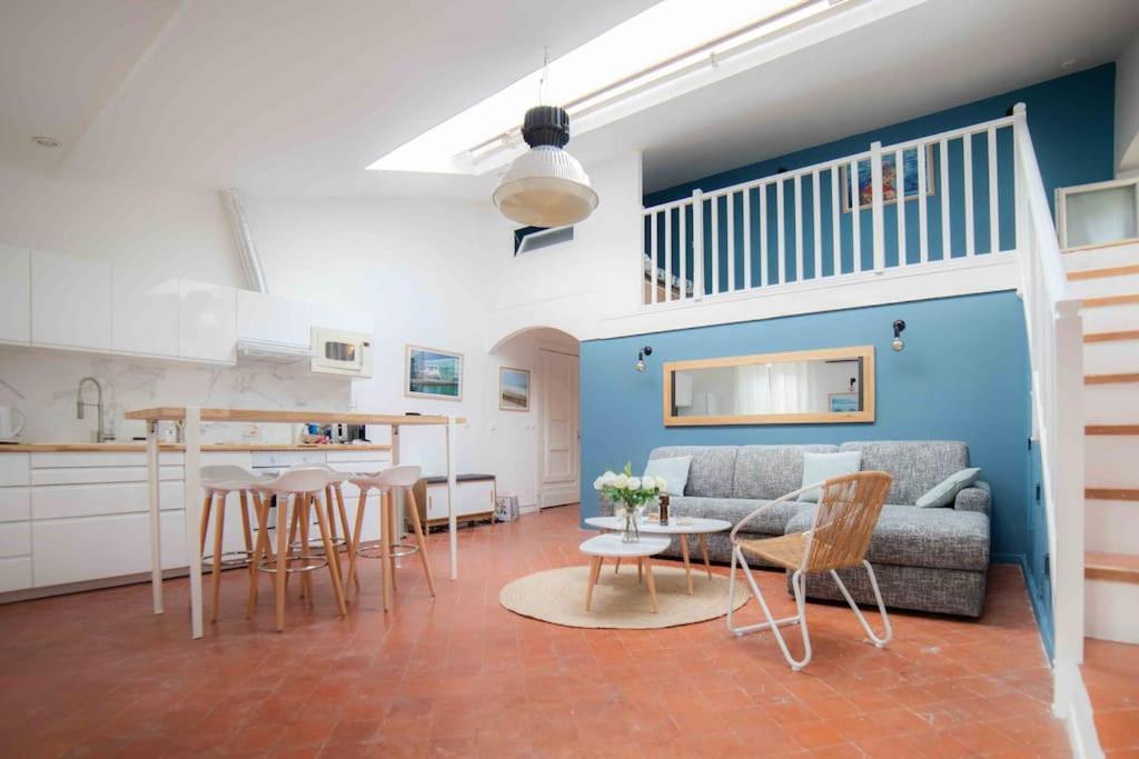 ein Wohnzimmer mit einem Sofa, einem Tisch und Stühlen in der Unterkunft Le Loft Saint Saëns in Marseille