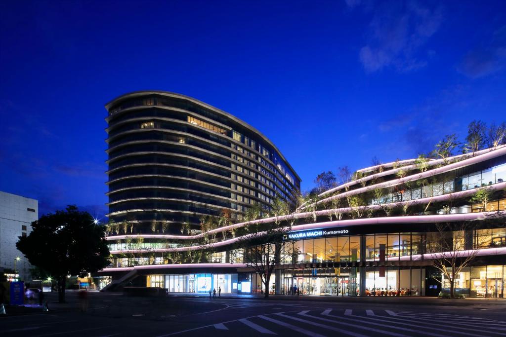 um edifício com muitas janelas à noite em KOKO HOTEL Premier Kumamoto em Kumamoto