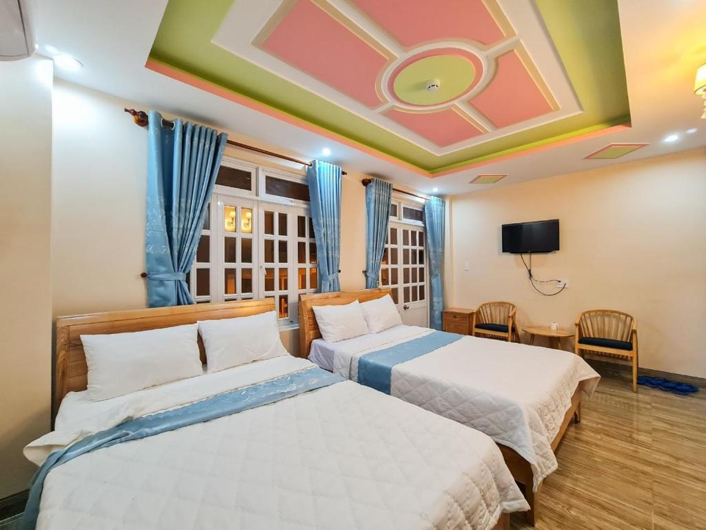 ブンタウにあるHotel Nắngのベッド2台とテレビが備わるホテルルームです。