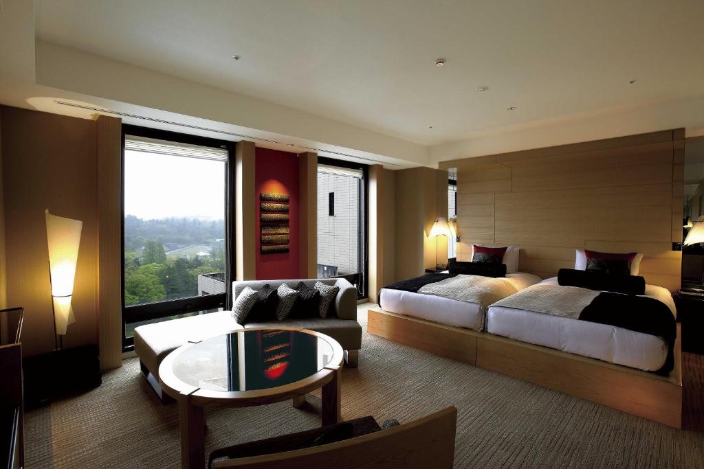 金沢市にあるKOKO HOTEL Premier Kanazawa Korinboのベッドとソファ付きのホテルルーム